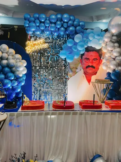 The cake table is ready for celebration, set against the personalized portrait and blue balloon decor. We ensure every element contributes to the overall theme.