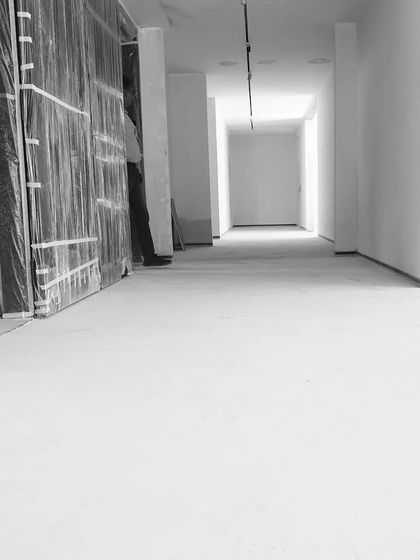 We love our site visits. This black and white photo captures the minimalist potential of a corridor during the construction phase, with clean lines and a long perspective.