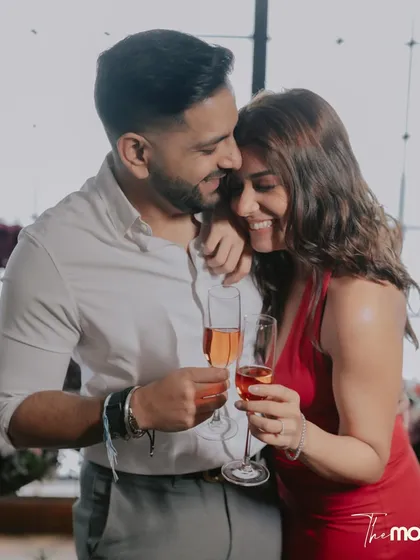 A happy, candid moment with champagne glasses at Soho House Mumbai. The couple's smiles and close embrace perfectly capture the celebratory and romantic mood.