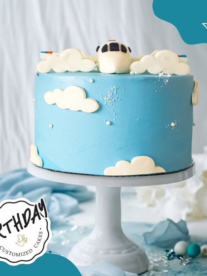 An airplane-themed cake soaring through fluffy clouds. This beautiful blue cake is perfect for a little one with big dreams of flying.