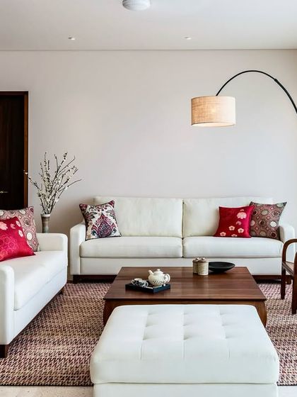 A full view of the living area in the Terrazzo Residence, showcasing the balance between the clean lines of the furniture and the warmth of the wooden coffee table and patterned rug.