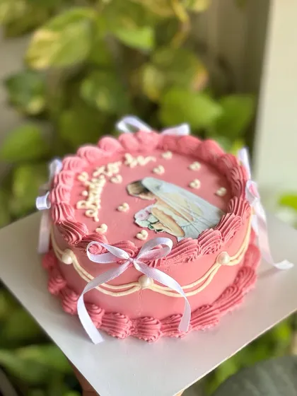 The perfect cake for a bride-to-be. This pink vintage design features an edible illustration of a bride, surrounded by piped hearts and tied with delicate white ribbons.
