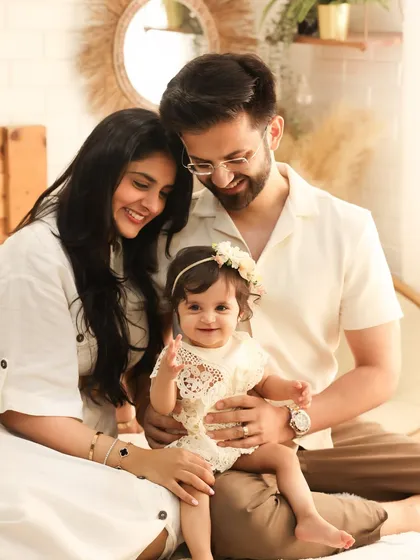 The perfect family hug. This beautiful portrait captures a family of three in a moment of pure connection. The coordinated white outfits and boho decor create a timeless and elegant look.