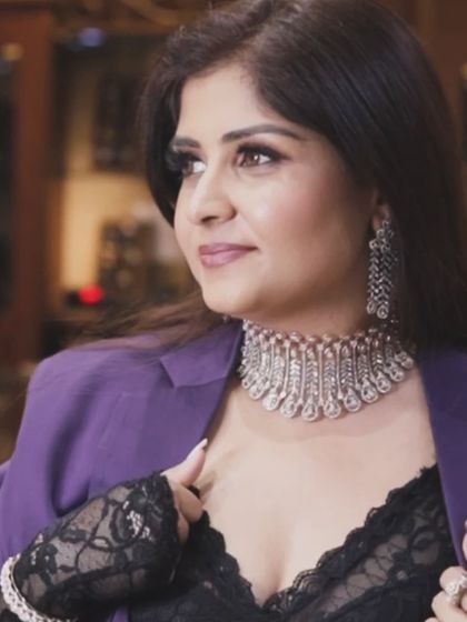 A close-up of a diamond choker paired with a purple power suit and lace details. This is how you mix professionalism with high fashion.