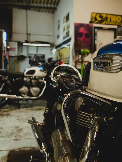 A beautiful shot of a classic Triumph Bonneville's tank, with another vintage Triumph in the background.