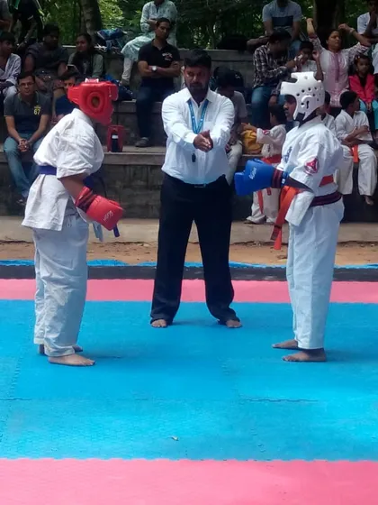 Two competitors listen to the referee's instructions before beginning their kumite match.