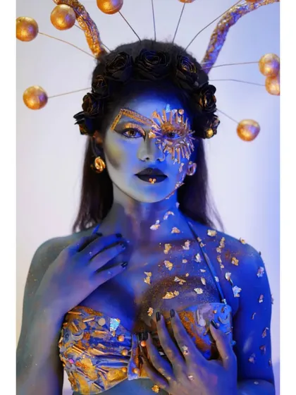 A powerful shot of the celestial goddess look, with dramatic lighting that makes the blue and gold colors pop.
