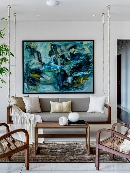 The indoor swing is a beloved feature in the Terrazzo Residence. Paired with classic wooden armchairs and a large piece of abstract art, it creates a relaxed yet sophisticated corner for reading or conversation.