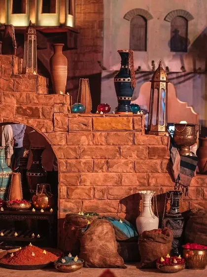 A recreation of a marketplace from old Arabia, complete with textured stone walls, clay pots, and rustic textiles. This area served as a photo backdrop and an interactive space for guests.