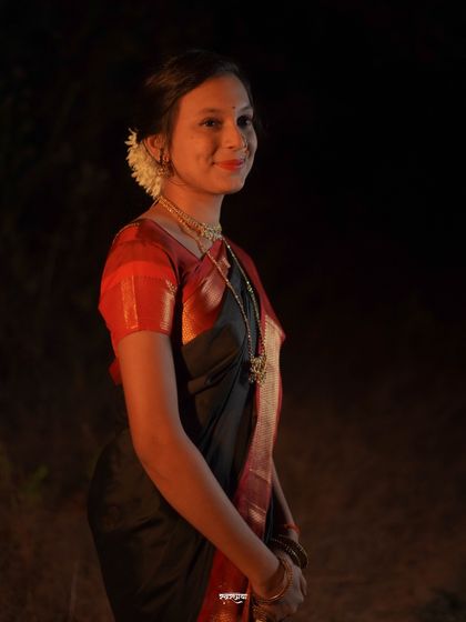 A simple and elegant side profile portrait taken during a Makar Sankrant shoot. The focus is on her serene expression and traditional attire, with the dark background making her stand out beautifully.