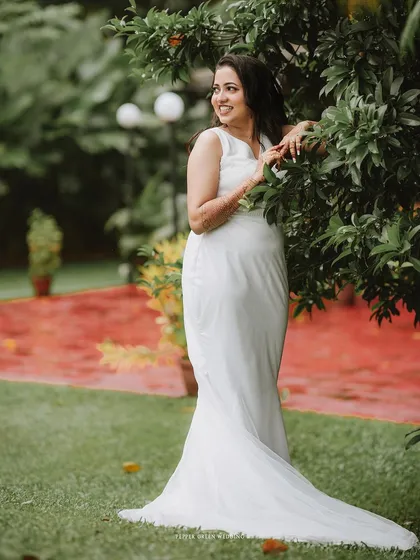 An elegant portrait of the bride in her white gown, posing gracefully in a garden.