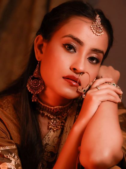 An intimate and captivating close-up. The warm, soft light highlights her beautiful features and the intricate details of her jewelry.