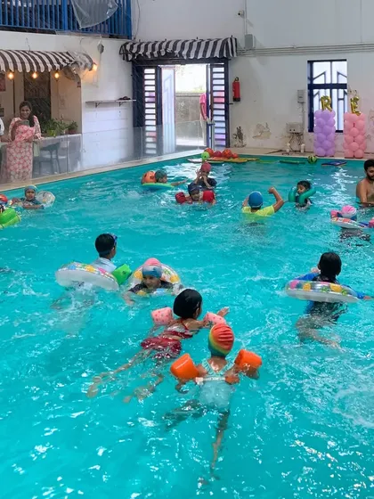A classic pool party scene with kids and adults enjoying our spacious indoor pool, perfect for a fun-filled bash.