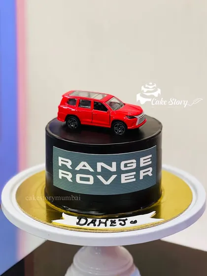 A mini cake for a Range Rover enthusiast. This sleek black cake features the Range Rover logo and is topped with a miniature model of the car.