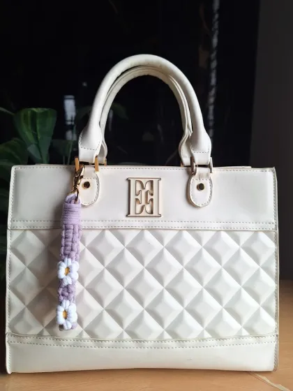 The daisy bag charm in a soft lavender color. These little floral accessories are one of our most popular items for gifting or as a small treat for yourself.