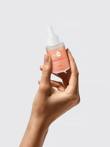 A minimalist shot of a hand holding the In'lief face serum bottle. This clean, isolated image is perfect for marketplaces like Amazon or for use in graphic design.