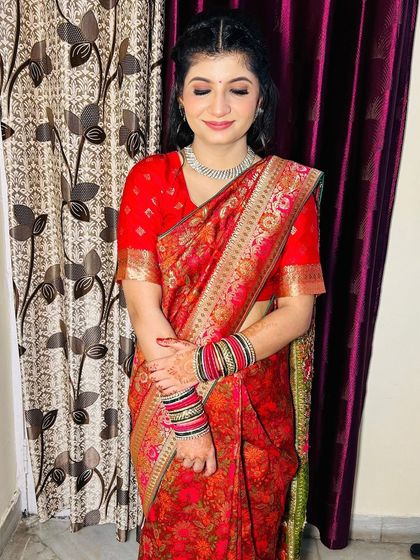 A close-up with eyes closed, highlighting the subtle eyeshadow and neat hairstyle.