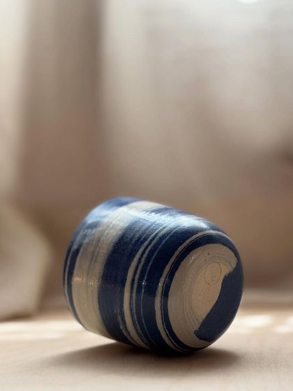 A Blue Fish Tumbler on its side, showing the beautiful swirls of the marbled clay. Each one is like a small, abstract painting.