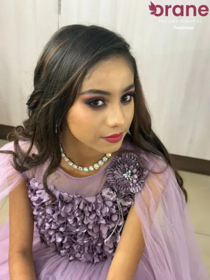 An evening party look featuring voluminous curls and a side-swept style. We teach our students how to create glamorous, red-carpet-ready hairstyles for any special event.