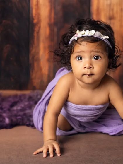 Look at that determination. This six-month-old is practicing her crawling skills during her purple-themed milestone photoshoot.