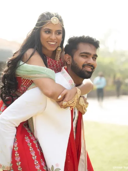 A fun piggyback ride during the Mehendi celebrations. It's these lighthearted, energetic moments that show a couple's true personality.