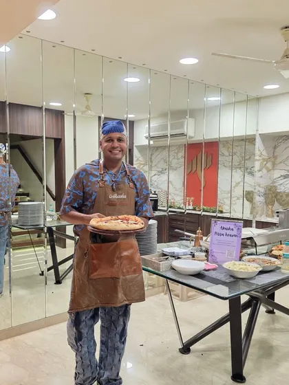 My setup for a birthday pizza party. You can see my table with all the fresh ingredients and the 'Akasha Pizza Heaven' sign, ready to serve guests.