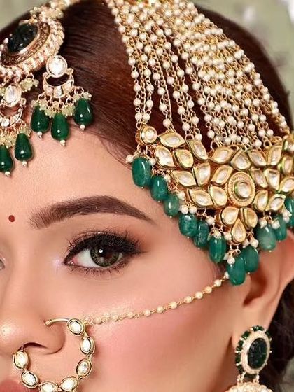 A model showcasing a beautiful passa, a traditional side-swept headpiece popular in Muslim weddings. This one features Kundan work with green bead drops.