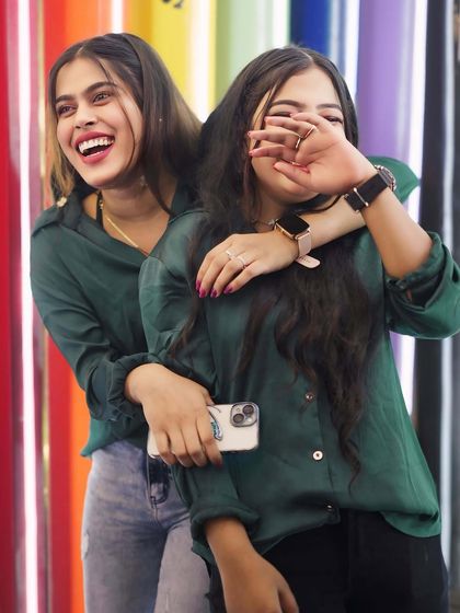 Two friends having a candid, happy moment at the entrance.