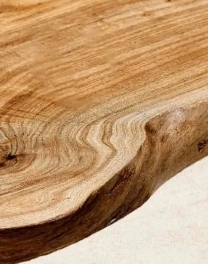 The natural, 'live' edge of a teak wood slab. I keep this edge to celebrate the original form of the tree, making every table a unique piece.