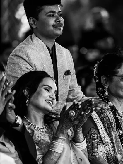 A black and white photo capturing the emotional reactions of the family as they watch the Sangeet performances.
