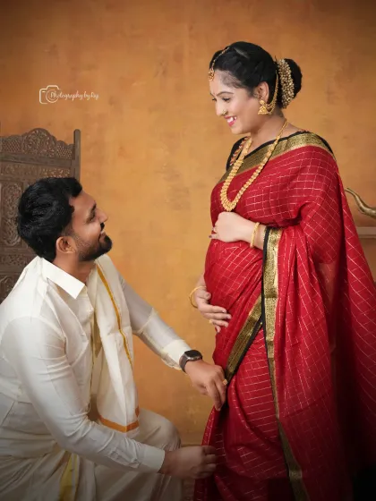 A romantic studio portrait of a couple in traditional attire, sharing a sweet moment.