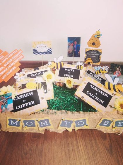 A rustic 'Mom to Bee' hamper with a jute-wrapped tray. It's filled with healthy dry fruits, each labeled with its nutritional benefit, like almonds for calcium and walnuts for copper.