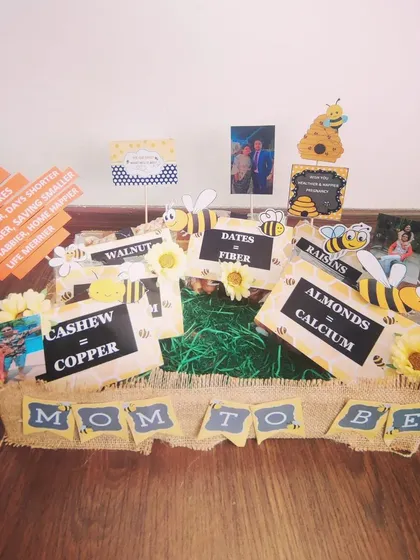 A rustic 'Mom to Bee' hamper with a jute-wrapped tray. It's filled with healthy dry fruits, each labeled with its nutritional benefit, like almonds for calcium and walnuts for copper.