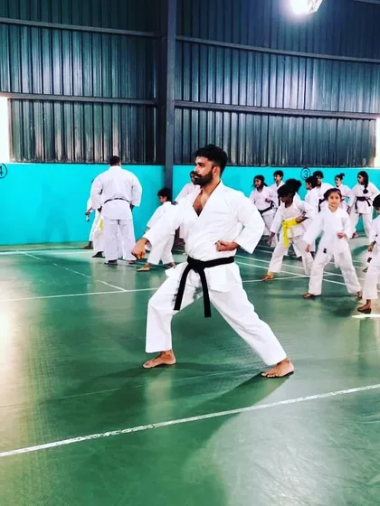 Leading by example is key to our teaching philosophy. Here, I am guiding a class through fundamental karate stances, ensuring every student understands the proper form and technique required for effective martial arts.