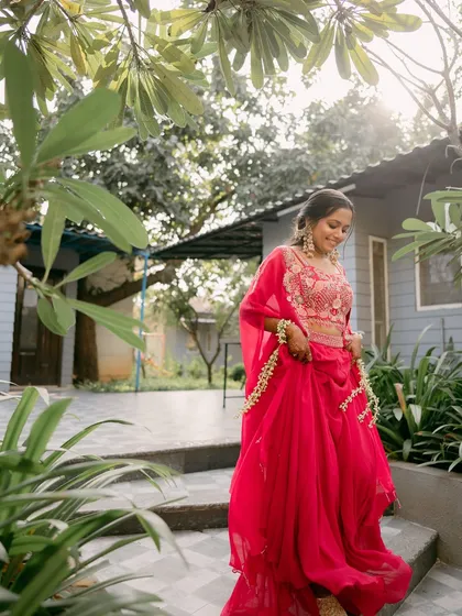 A full-length shot of the bride walking, her pink outfit flowing beautifully.