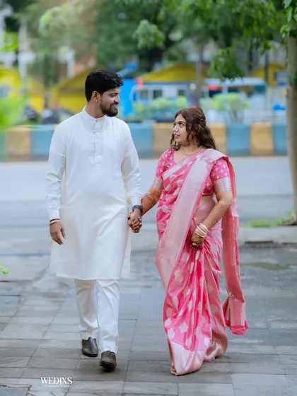 A candid shot of a couple walking hand-in-hand, capturing a natural and happy moment during their engagement day.