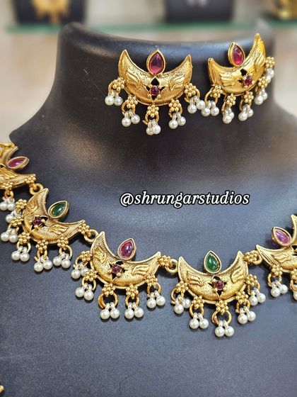 This Chandra (moon) motif copper combo set is a trending piece. It's lightweight and looks beautiful with Paithani sarees.