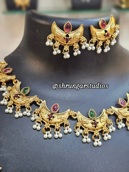 This Chandra (moon) motif copper combo set is a trending piece. It's lightweight and looks beautiful with Paithani sarees.