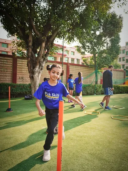 A young girl smiles during an agility drill. Pursuing what you love should be fun, and we make sure our training sessions are filled with positive energy.