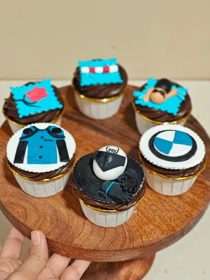 I love bringing your hobbies to life with custom cupcakes. This set was for a couple who loves biking and swimming, featuring fondant details like a BMW logo, a biker's jacket, and a swimmer in the water.