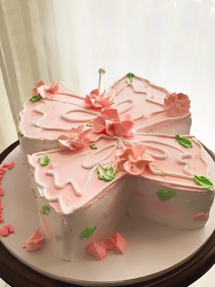 Another take on the butterfly-shaped cake, this one in a soft pink with delicate piping and floral details.