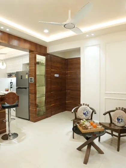 Our expertise goes beyond just kitchens. We design complete, cohesive home interiors, like this living space that seamlessly integrates an open kitchen and breakfast bar with warm wooden textures and elegant decor for a unified look.