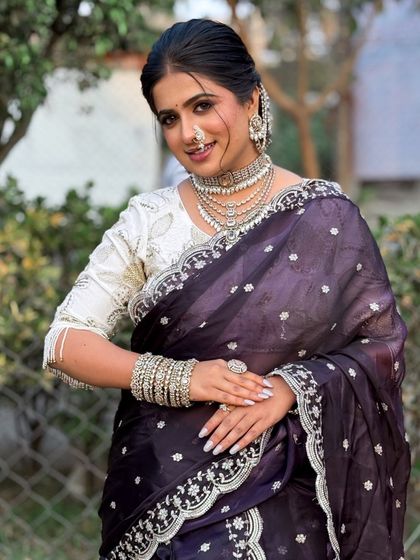 This image showcases the complete Maharashtrian bridal attire. The makeup is kept fresh and radiant to balance the heavy jewellery and embroidered saree, ensuring the bride's natural beauty shines through.