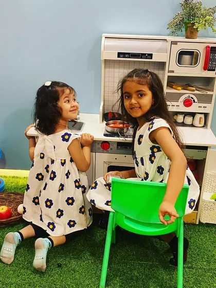 Sisters cooking up some fun together in our play kitchen. It's a wonderful space for siblings to bond and play.