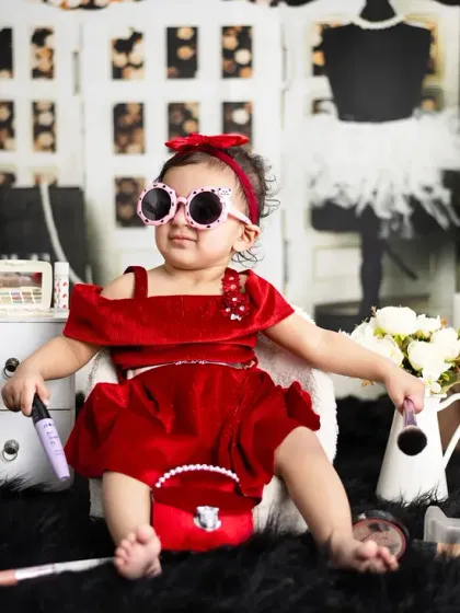 This little fashionista is striking a pose with her sunglasses and purse. We love the playful attitude in this shot.