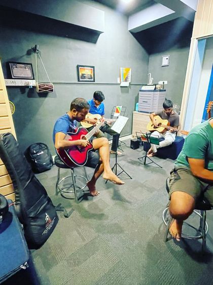 A group of students enjoying a guitar lesson together. Our group sessions foster a sense of community and collaborative learning.