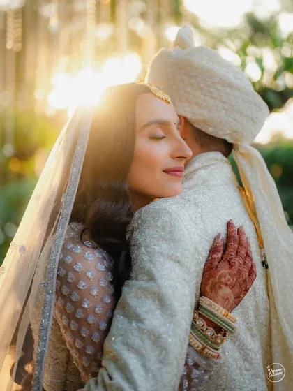 A heartfelt hug between the bride and groom, captured in the warm, magical glow of the setting sun.