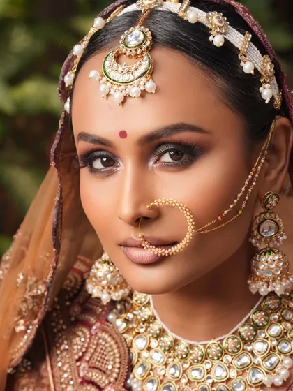 A powerful, direct portrait that showcases the intensity of the smokey eye and the intricate jewelry.