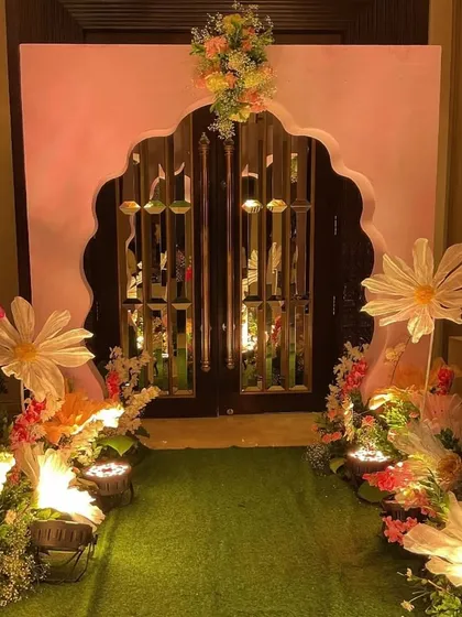 We created a magical entrance for the cradle ceremony, lining a green turf walkway with oversized, illuminated paper flowers and leading to a grand, floral-adorned archway.