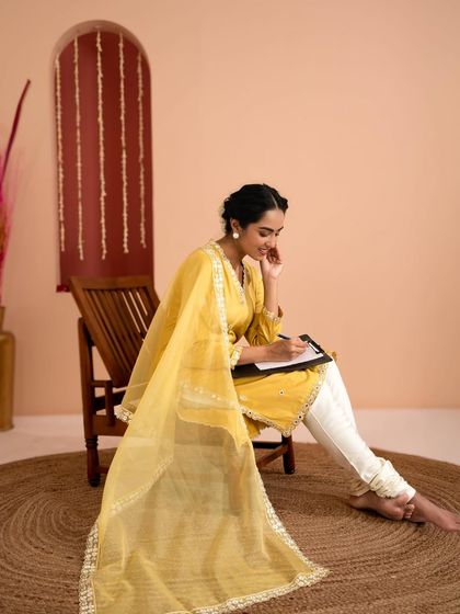 This portrait captures a gentle smile, adding warmth and approachability to the ethnic wear collection. The focus remains on the detailed embroidery of the kurta and the graceful drape of the fabric.